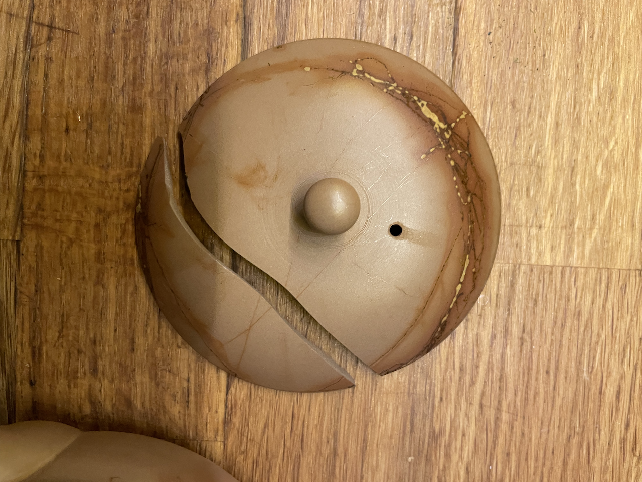 Le couvercle brisé en deux morceaux.