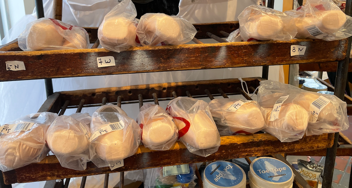 Pointe shoes in a row on wooden shelves at the dance store.